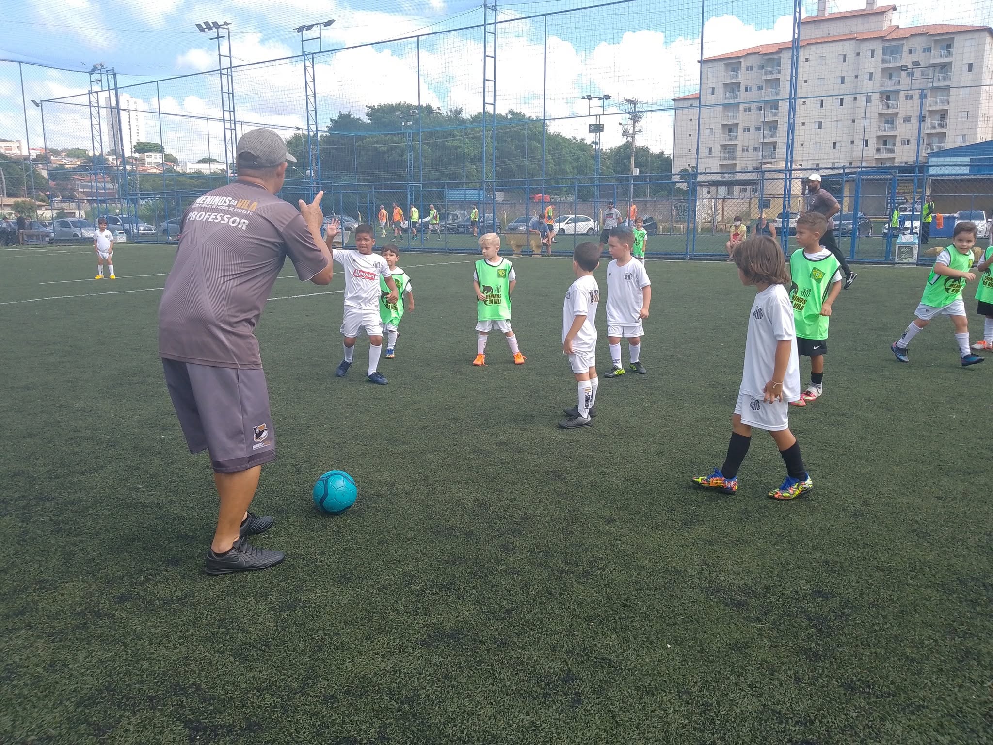 Professor orientando alunos em treino de futebol